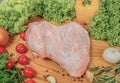 Fresh turkey meat, turkey wing on a cutting wooden board with cherry tomatoes, lettuce leaves, garlic, chilli pepper Royalty Free Stock Photo