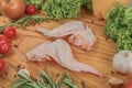 Fresh turkey meat, turkey wings on a cutting wooden board with cherry tomatoes, lettuce leaves, garlic, chilli pepper Royalty Free Stock Photo