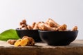 Fresh turmeric in a bowl on wooden with white background, Food ingredients in Asian food