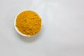 Fresh turmeric powder in ceramic bowl with blurred white Background studio shot Royalty Free Stock Photo