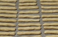 Fresh unbaked cheese sticks on a baking paper for background