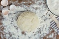 Fresh unbaked dough in flour on wooden table top