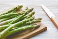 Fresh uncooked asparagus on a wooden cutting board. Close up view Royalty Free Stock Photo