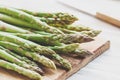 Fresh uncooked asparagus on a wooden cutting board. Close up view Royalty Free Stock Photo