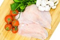 Fresh uncooked chicken meat breast pieces, ready to cook, with tomatoes greens and mushrooms Royalty Free Stock Photo