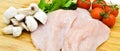 Fresh uncooked chicken meat breast pieces, ready to cook, with tomatoes greens and mushrooms Royalty Free Stock Photo