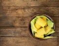 Cut raw corn in ceramic plate with leaves on rustic wood textured table. Healthy summer food concept. Fresh uncooked Royalty Free Stock Photo