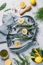 Fresh uncooked dorado or sea bream fish with lemon, herbs, oil, vegetables and spices on concrete background. Top view Royalty Free Stock Photo