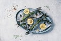Fresh uncooked dorado or sea bream fish with lemon, herbs, oil, vegetables and spices on concrete background. Top view Royalty Free Stock Photo