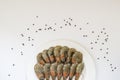 Fresh uncooked king prawns in a white plate and black pepper peas on a white background. Delicacy, tasty and healthy sea food, Royalty Free Stock Photo