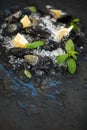 Fresh uncooked mussels with lemon, herbs and spices on chipped ice over dark slate stone backdrop Royalty Free Stock Photo