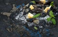 Fresh uncooked mussels with lemon, herbs and spices on chipped ice over dark slate stone backdrop Royalty Free Stock Photo