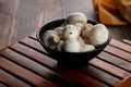 Fresh Uncooked Organic Button Mushrooms in a Black Bowl