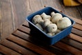 Fresh Uncooked Organic Button Mushrooms in Retail Plastic Box