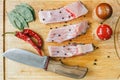 Fresh uncooked pieces of silver carp fish with red chile pepper, bay leaf, spices and knife on wooden board, top view. Royalty Free Stock Photo