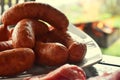 Fresh uncooked red meat, sausages and meatballs on the wooden table ready to be cooked on the outdoor fire grill. Barbecue  in the Royalty Free Stock Photo