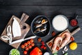 Fresh uncooked sea food specialties and rice with mussels, shrimps and squid on black wooden background, flat lay with copy space Royalty Free Stock Photo