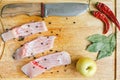 Uncooked pieces of silver carp fish with red chile pepper, bay leaf, apple, spices and knife on wooden board, top view. Royalty Free Stock Photo