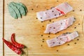 Uncooked pieces of silver carp fish with red chile pepper, bay leaf, apple, spices and knife on wooden board, top view. Royalty Free Stock Photo