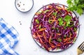 Fresh vegan coleslaw salad with red cabbage, carrot, parsley and olive oil dressing on white kitchen table background, top view Royalty Free Stock Photo