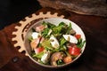 Fresh Vegan Salad with Vegetables, Fish, Cheese, Egg, Pumpkin Seeds, Arugula in White Ceramic Bowl on a Leather Apron Royalty Free Stock Photo