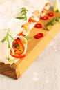 Fresh vegan tortilla wraps with bell pepper, tomato and cucumber on wooden cutting board with lime and chili pepper.