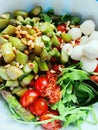 Fresh vegeratian salad with green asparagus, mozarella, tomatoes, arugula and pine nuts. Healthy lunch food or salad for Royalty Free Stock Photo