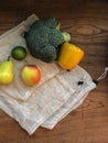 Fresh vegetable and fruit on cotton shopping bags on wooden table. Vertical. No plastic concept. Copy space