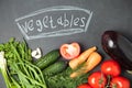 Fresh vegetable on graphite board with an inscription. Top view. onion, garlic , parsley , cucumber , eggplant , tomato and dill Royalty Free Stock Photo