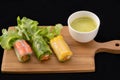 Fresh vegetable noodle spring roll with sauce on wooden tray,