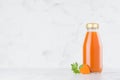 Fresh vegetable orange carrot juice in glass bottle template with green parsley, slices on wood table and white background. Royalty Free Stock Photo