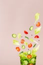 Fresh vegetable salad in craft box for take away food with flow of flying slices of ingredients - cherry tomato, cucumber, green. Royalty Free Stock Photo