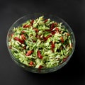 Fresh vegetable salad in a glass bowl on a dark background. Cucumbers, tomatoes, peppers. Close-up Royalty Free Stock Photo