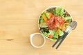 Fresh vegetable salad lettuce, carrot, cucumber, tomato  with fried bacon and roasted sesame Japanese dressing in white bowl Royalty Free Stock Photo