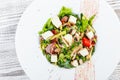 Fresh vegetable salad with prosciutto, spinach, mushrooms, tomatoes, cheese, onions, cucumbers and avocado on plate Royalty Free Stock Photo