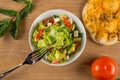 Fresh vegetable salad seasoned with oil on a wooden background