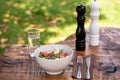 Fresh vegetable salad served on a bowl with mixed green leaves, eggs, black olives and tomato on a wooden rustic table with Royalty Free Stock Photo