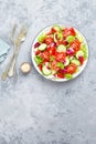 Fresh vegetable salad with tomatoes, cucumbers, sweet pepper and sesame seeds. Vegetable salad on white plate Royalty Free Stock Photo