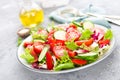 Fresh vegetable salad with tomatoes, cucumbers, sweet pepper and sesame seeds. Vegetable salad on white plate Royalty Free Stock Photo