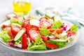 Fresh vegetable salad with tomatoes, cucumbers, sweet pepper and sesame seeds. Vegetable salad on white plate Royalty Free Stock Photo