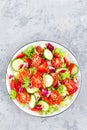 Fresh vegetable salad with tomatoes, cucumbers, sweet pepper and sesame seeds. Vegetable salad on white plate Royalty Free Stock Photo