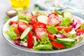 Fresh vegetable salad with tomatoes, cucumbers, sweet pepper and sesame seeds. Vegetable salad on white plate Royalty Free Stock Photo