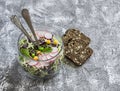 Fresh vegetable salad with white and red cabbage, cucumber, radish and cilantro in a glass jar on a stone texture. Royalty Free Stock Photo