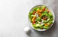 Fresh vegetable salad with yellow and red tomatoes, avocado, cucumber, mixed salad leaves