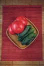 A fresh vegetable set of cucumbers and tomatoes on a bamboo plate