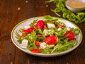 Fresh vegetable strawberry salad on white plate on natural rusti