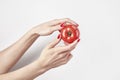 Fresh vegetable tomato in woman`s hands, fingers with red nails manicure, isolated on white background, healthy lifestyle concept.