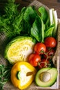 Fresh vegetable on wooden background. Tomatoes, cabbage, pepper, green onion, avocado, dill and parsley. Top views, close-up Royalty Free Stock Photo