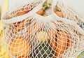 Fresh vegetables in a blue beige reusable cotton mesh bag on beige background.  Eco-friendly shopping bag. Zero waste grocery Royalty Free Stock Photo