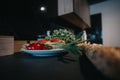 Fresh vegetables with bread on kitchen counter under warm light. Royalty Free Stock Photo